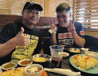 トレーニングキャンプで食事をするボクサーとトレーナー