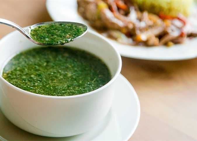 طبق من حساء الملوخية الخضراء، يمثل القيمة الغذائية والثقافية للخضروات ودورها في المجتمع.