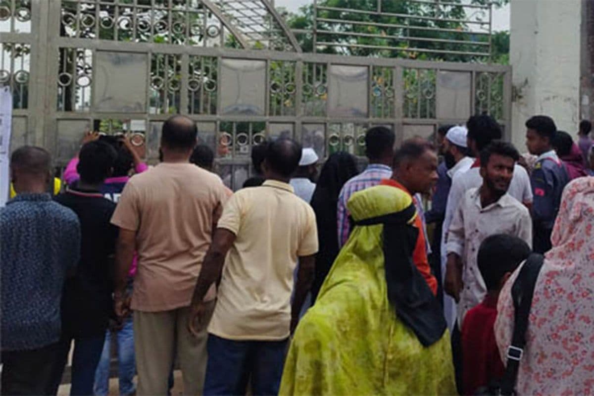 ঢাকার একটি স্কুলের প্রবেশপথে মানুষের ভিড়, যা শহরের দৈনন্দিন জীবনের চিত্র তুলে ধরে।