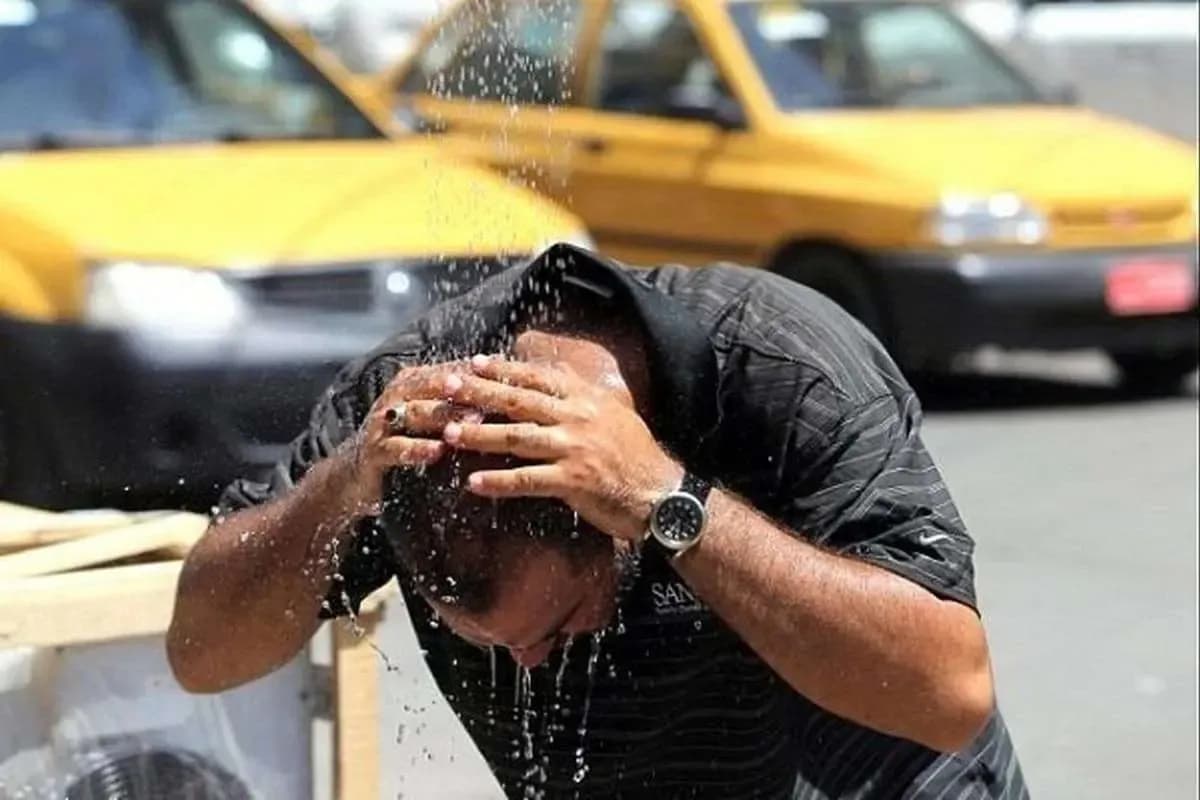 مردی در حال خنک کردن خود در گرمای شدید، نمادی از خشکسالی و تغییرات اقلیمی