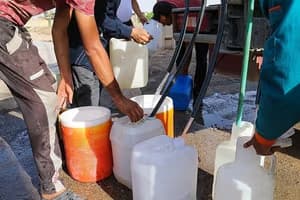 مردم ایران در حال جمعآوری آب آشامیدنی از نقاط توزیع، نشاندهنده جیرهبندی و کمبود آب