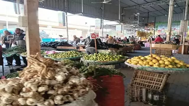 سوق خضروات وفاكهة واسع يعرض مجموعة متنوعة من المنتجات الطازجة، يرمز إلى 'الذهب الأخضر' وتأثيره العالمي.