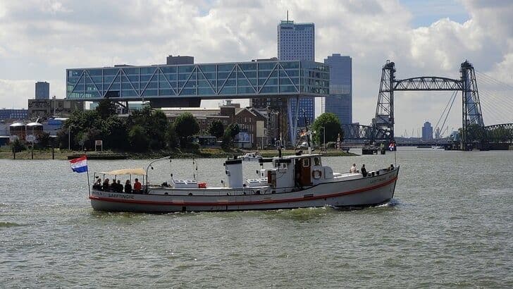 A boat on a river under a cloudy sky, reflecting the cool, unexpected start to summer before temperatures rise.