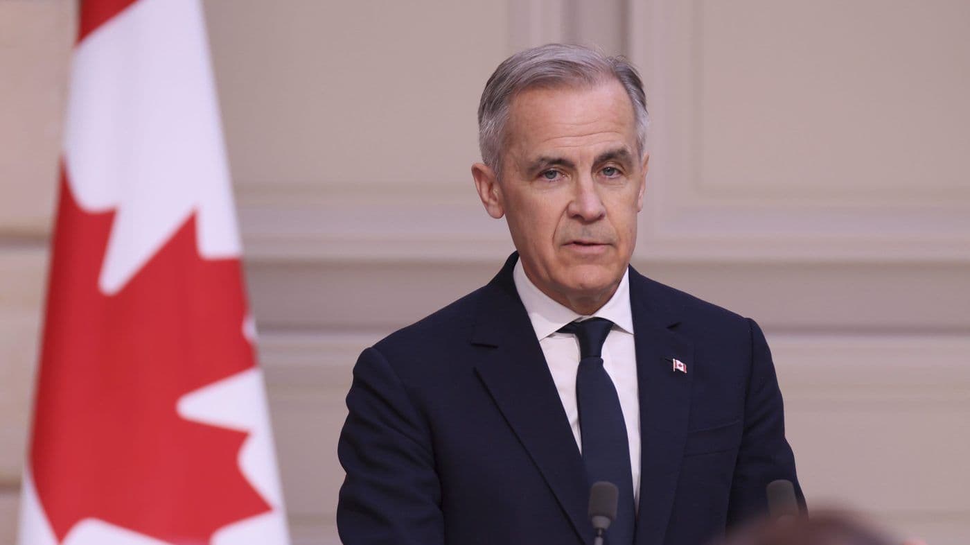 A Canadian official speaking in front of the Canadian flag, representing Canada's strategic response and diplomatic engagement.