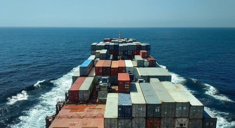 A cargo ship navigating open waters, representing the critical nature of global maritime shipping lanes.
