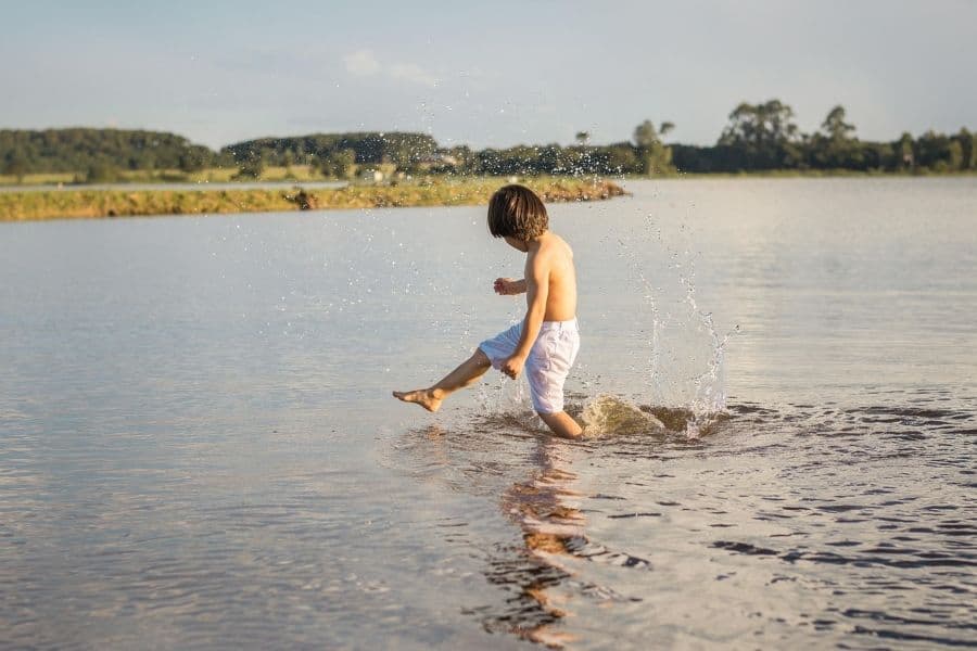 A child splashing in a lake, representing the warm, inviting weather perfect for outdoor activities in Hungary's August.