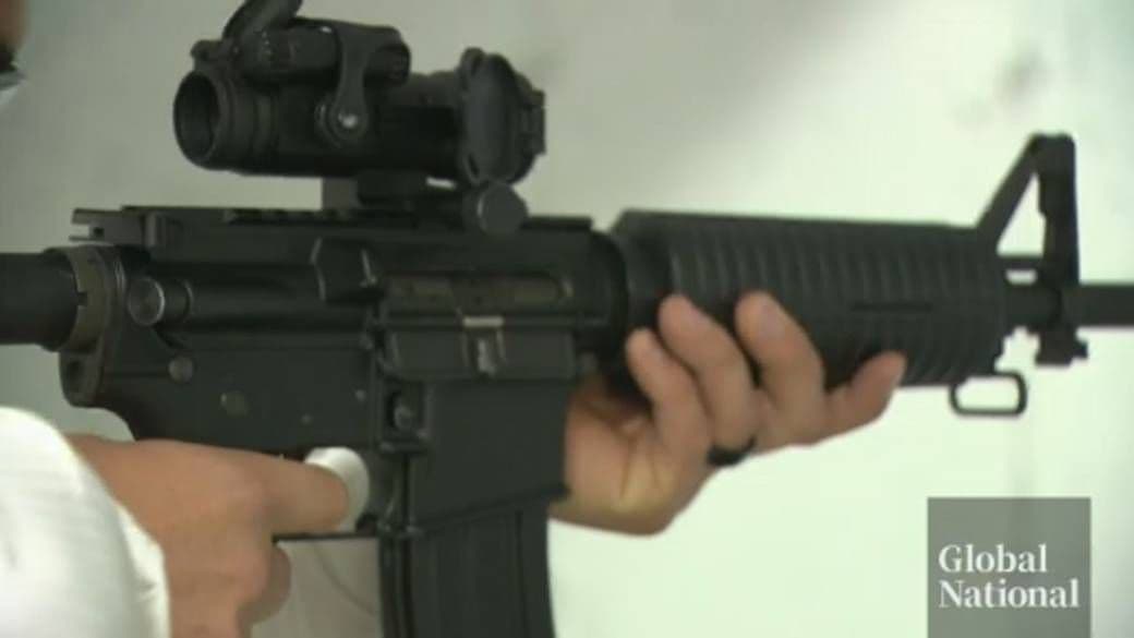 A close-up of a person holding an assault-style rifle, representing the federal gun buyback program.