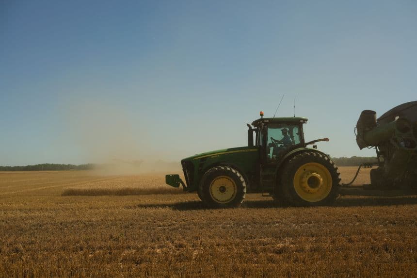 A farmer harvesting wheat in a field, representing agricultural production supported by the new USDA relief program.
