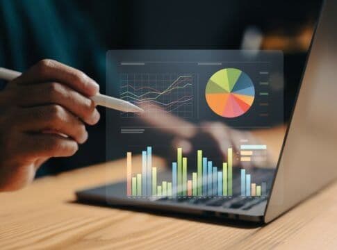 A hand using a stylus on a laptop displaying charts, symbolizing the digital application process for the pass.
