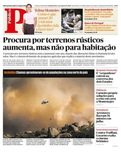 A helicopter flies through thick smoke over a burning landscape, illustrating a wildfire crisis in Portugal.