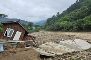 A house damaged by a severe flood in a Korean village, illustrating the destructive impact of extreme precipitation events driven by climate change.