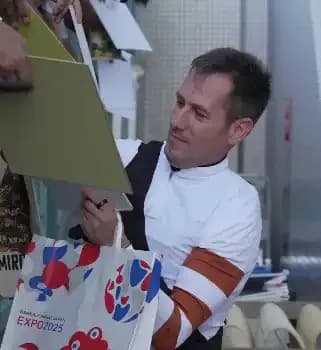 A jockey signing autographs for fans, symbolizing the lasting legacy and public impact of a landmark victory in horse racing.