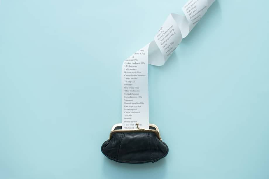 A long paper receipt or financial list emerging from a wallet, symbolizing financial data and the process of tax compliance.