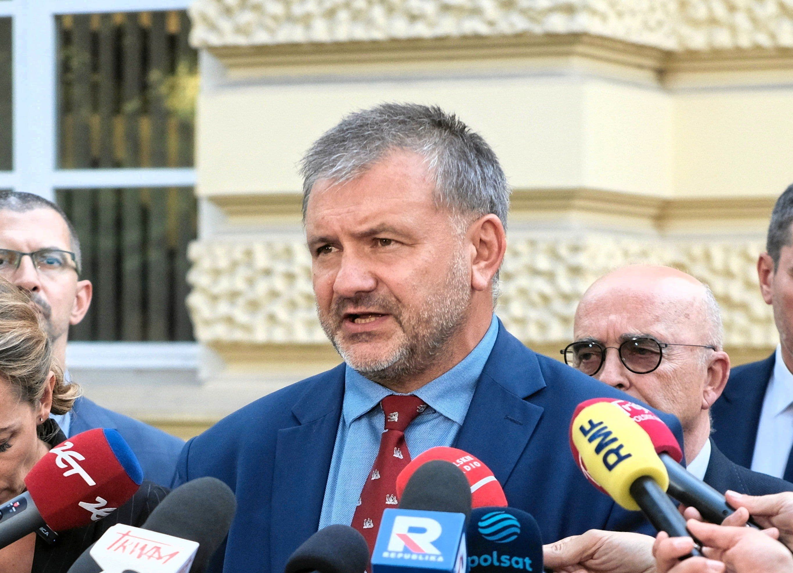 A public figure speaking into multiple microphones, representing Onet's role in shaping public discourse and comprehensive news coverage.