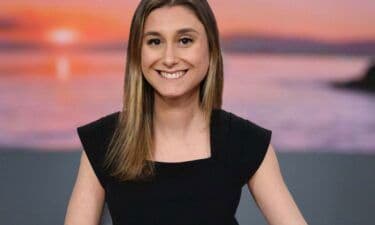 A smiling meteorologist or weather presenter, symbolizing the human expertise in weather forecasting.