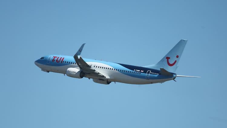 A TUI branded airplane taking off against a clear blue sky, symbolizing TUI's strategic surge and growth in the travel sector.