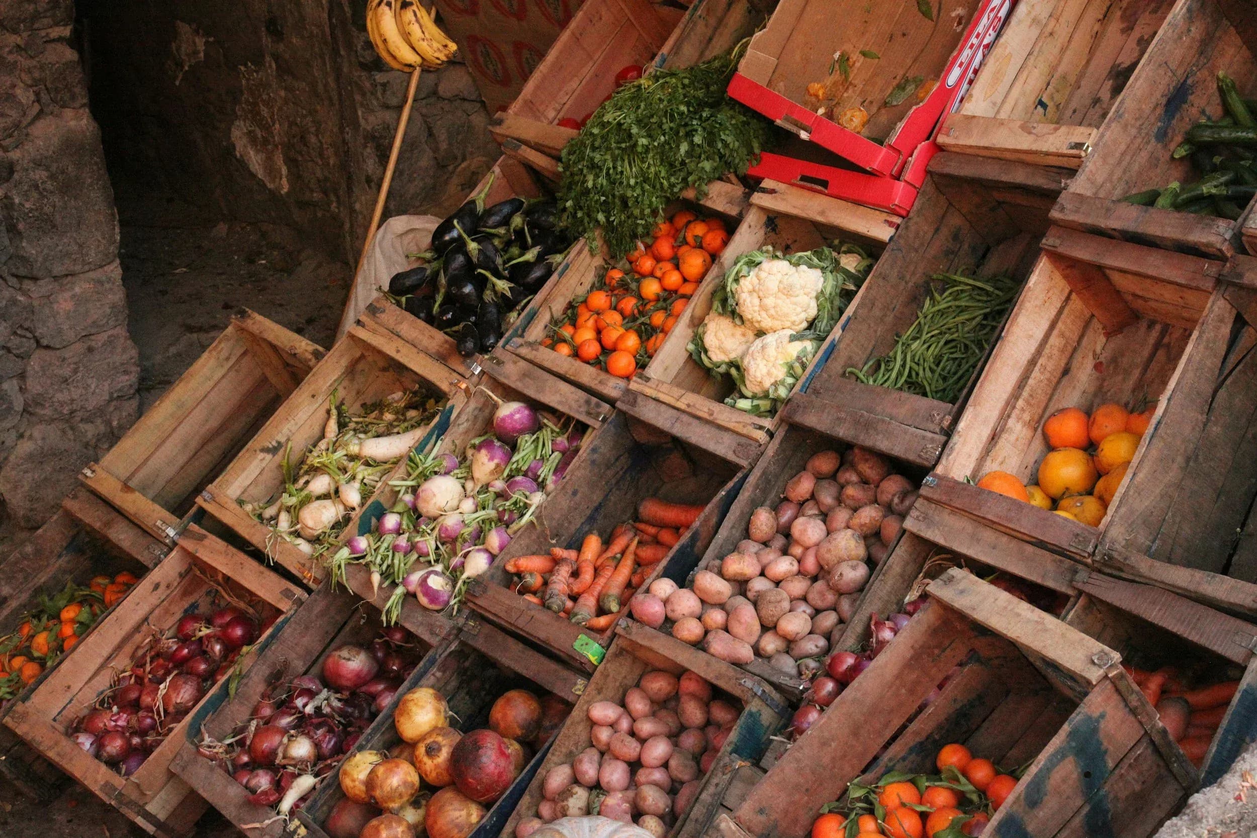 A variety of fresh produce displayed in wooden crates at a market.