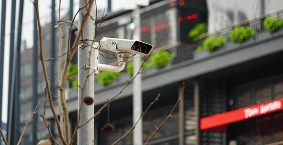 A white traffic camera mounted on a pole in an urban setting, representing Chile's new Ley CATI automated enforcement system.