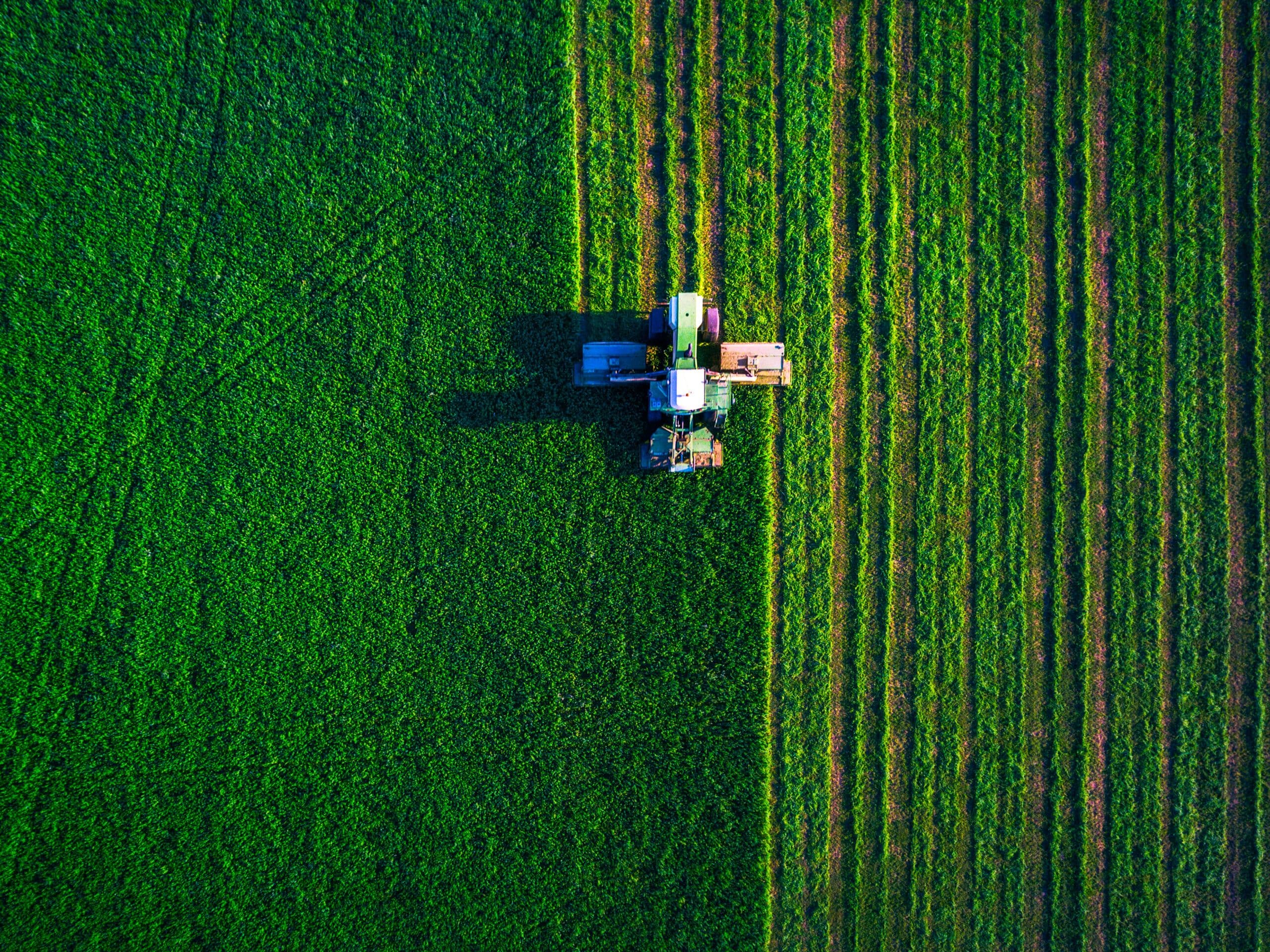 Aerial view of a tractor working in an agricultural field representing the European farming context.