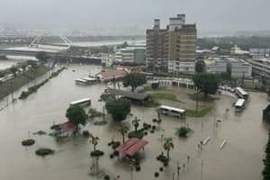 Aerial view of Taichung city heavily flooded after a severe rainstorm, with submerged roads and buildings.