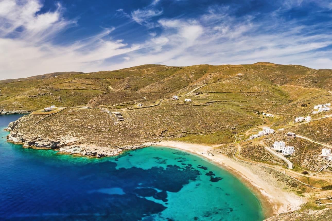 Agios Sostis beach in Kythnos with clear blue waters and traditional Cycladic architecture.