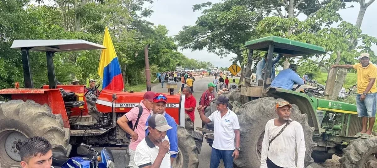 Agriculteurs du Tolima bloquant une route avec des tracteurs lors d'une manifestation.