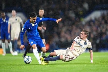Ajax's Kenneth Taylor makes a red card challenge on Chelsea's Facundo Buonanotte, a pivotal moment in the Champions League match.