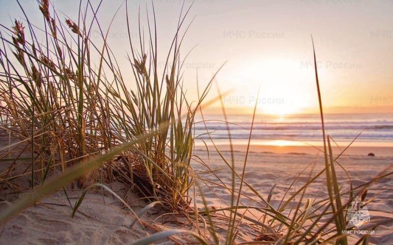 Alerte canicule sur le Kraï de Krasnodar, avec le soleil se couchant sur une plage.