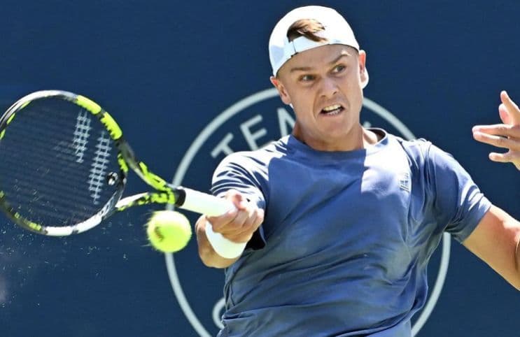 Alex Michelsen en pleine action sur un court de tennis, symbolisant son ascension et son défi à l'élite.