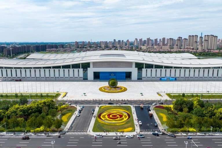 An aerial view of a modern city skyline and a large convention center, representing the SCO's vast community and economic influence.