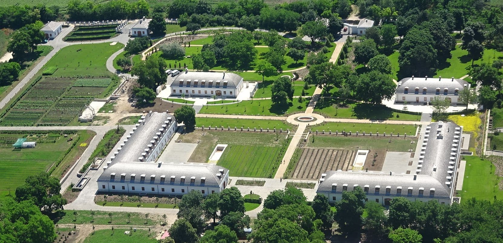 An aerial view of the expansive and luxurious Hatvanpuszta estate, featuring multiple large buildings and manicured grounds.