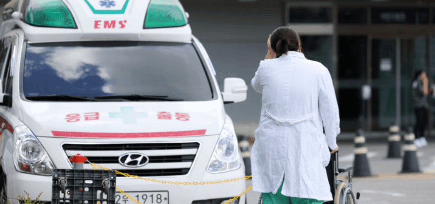An ambulance and medical professional, signifying the heightened public health risks and heat-related illnesses in Gwangju.