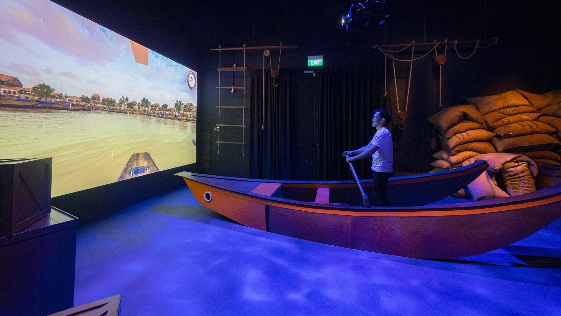 An interactive museum exhibit featuring a traditional boat on a simulated river, symbolizing Singapore's historical and ongoing reliance on trade and its maritime heritage.