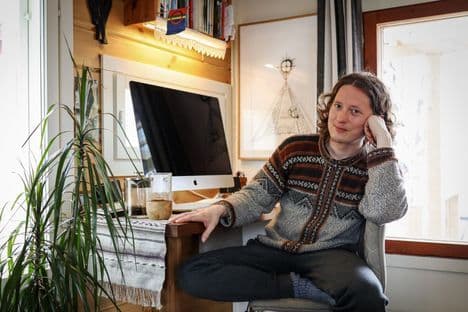 Aslak Holmberg, a Sámi fisherman, teacher, and activist, sitting in his home, representing the local community impacted by river changes.