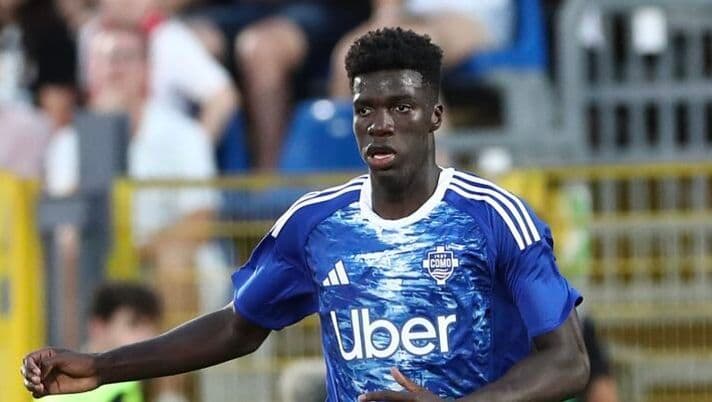 Assane Diao, joueur du Como, en maillot bleu sur le terrain, représentant son talent et les défis de sa carrière.
