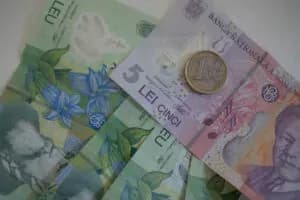 Bancnote și monede, reprezentând aspectele financiare și de valoare ale tranzacției.