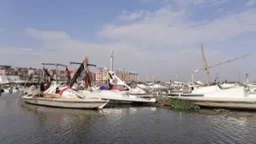 Bateaux dans un port égyptien, potentiellement affectés par la brume matinale et les vents.