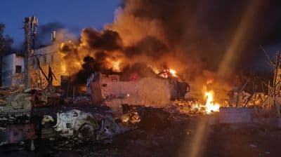 Bâtiment en feu et détruit la nuit à Chernomorsk, illustrant les dégâts des attaques de drones.