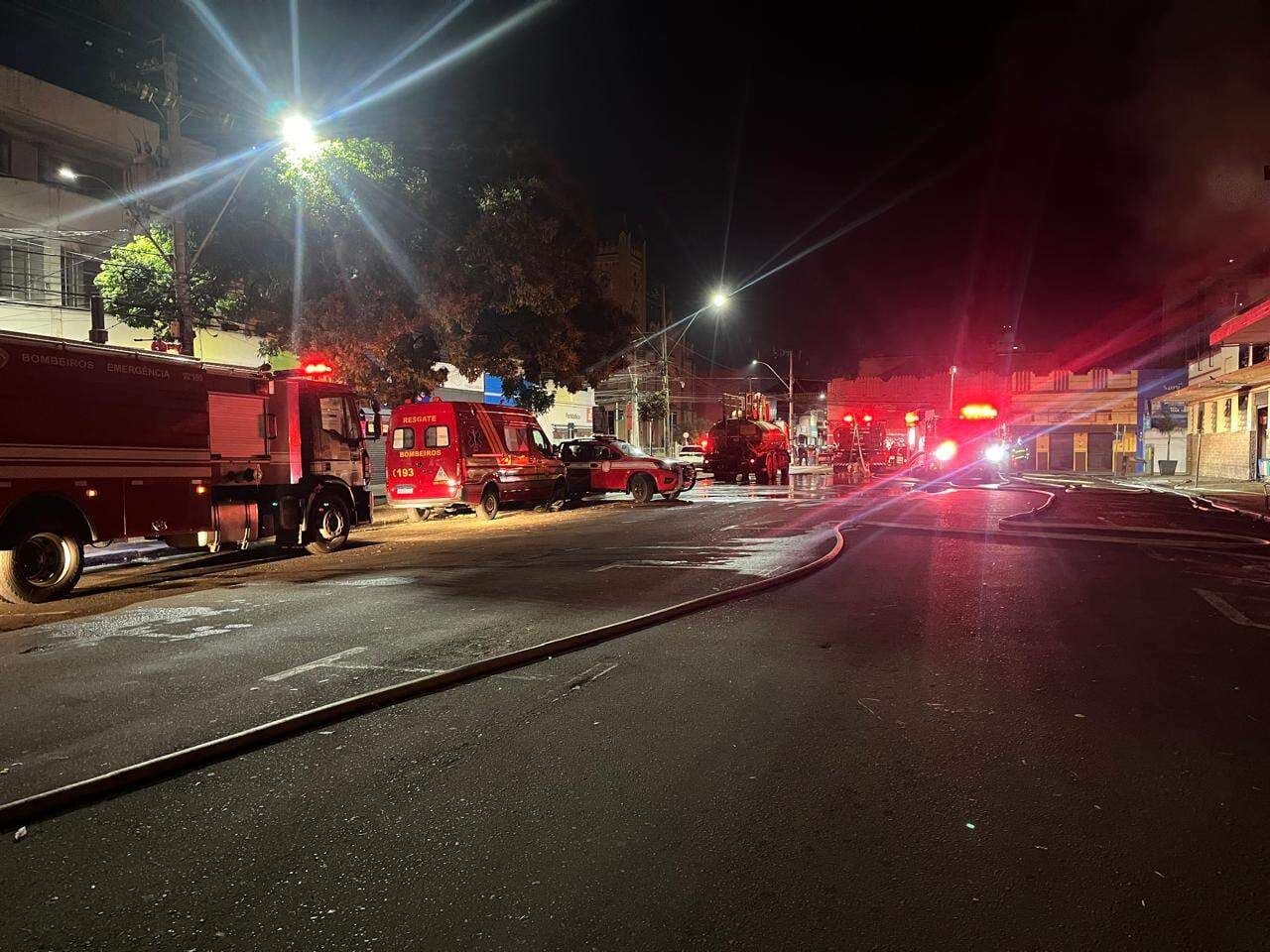 Caminhões de bombeiros e equipes de emergência na rua em frente ao Mercado Municipal de Piracicaba durante o combate ao incêndio.