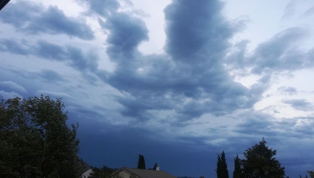 Ciel menaçant avec des nuages d'orage au-dessus d'un paysage, représentant une vigilance orange aux orages en France.