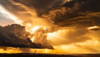 Ciel orageux avec des rayons de soleil perçant les nuages sombres