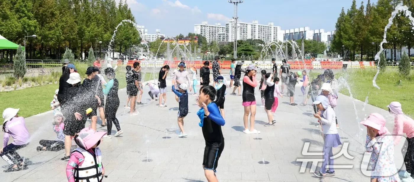 Citizens cool off in a Gwangju water park, illustrating local impacts and coping strategies during record heatwaves.