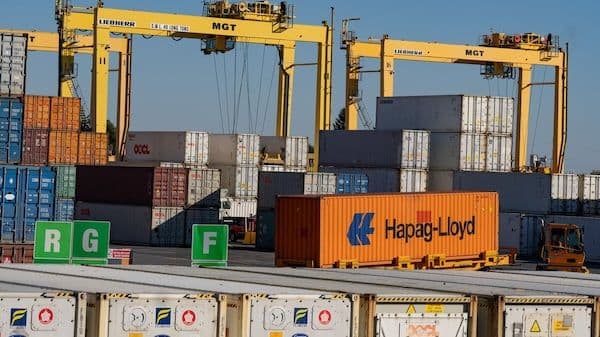 Conteneurs d'expédition dans un terminal portuaire, représentant les chaînes d'approvisionnement et l'intégration économique.