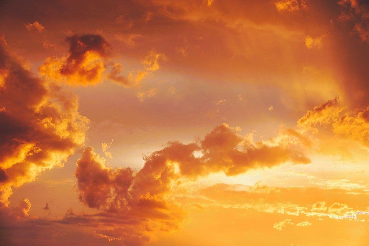 Céu com nuvens alaranjadas e avermelhadas ao pôr do sol, representando o calor intenso e ar seco no Nordeste do Brasil.