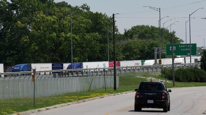 Des camions de transport sur une autoroute, représentant les chaînes d'approvisionnement et les défis rencontrés par les industries canadiennes sous la pression des tarifs.