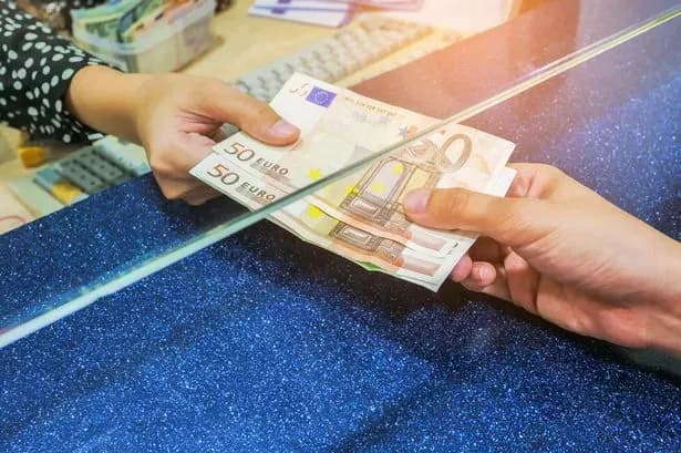 Des mains échangeant des billets en euros, représentant la campagne de collecte de fonds GoFundMe pour Féile.