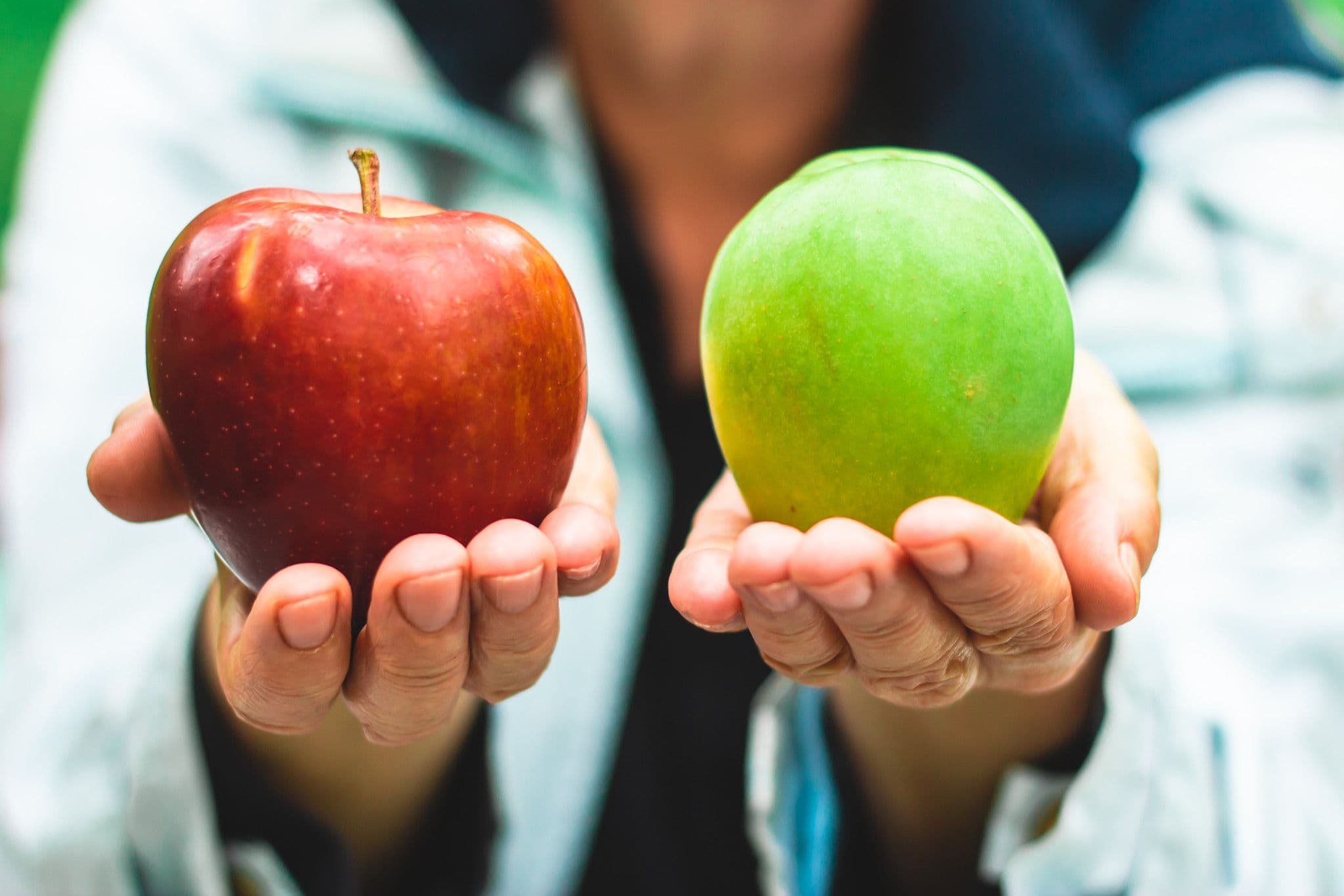 Des mains tenant deux pommes, symbolisant le paradoxe entre la croissance des prix et le déclin des volumes de vente de Nestlé.