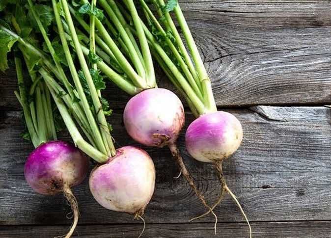 Des navets frais avec leurs fanes vertes, posés sur une surface en bois, évoquant la vitalité et les bienfaits naturels des légumes.