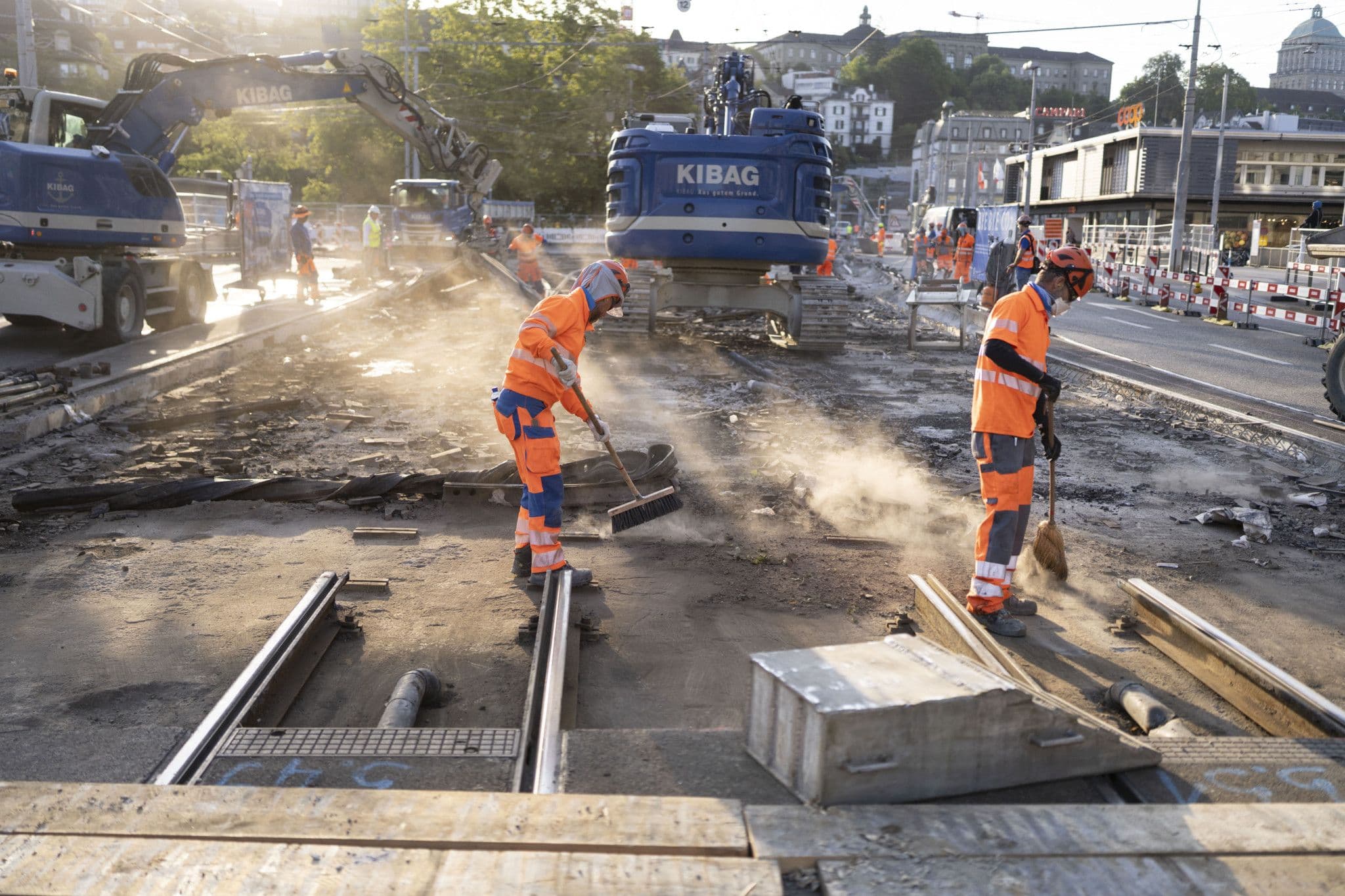 Des ouvriers nettoient une zone urbaine, symbolisant les efforts de reconstruction et de revitalisation après un événement majeur.