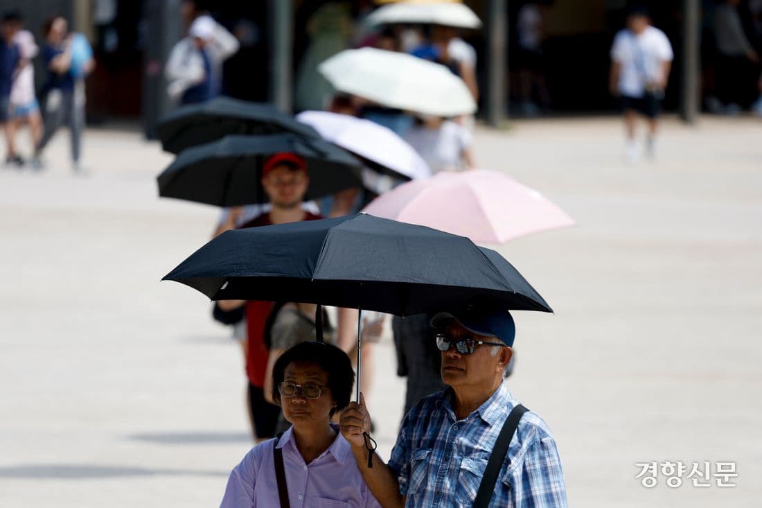 Des personnes utilisant des parasols pour se protéger du soleil intense lors d'une canicule.